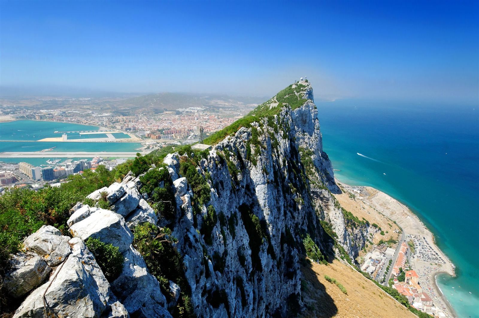 The limestone ridge of the Rock of Gibraltar seen from the top, with the bay, the town and the turquoise sea below